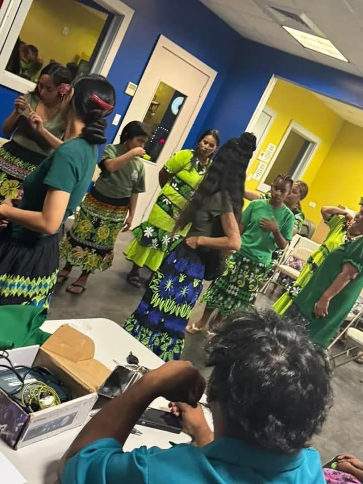 Young people from the church dancing together in green island dress during a fellowship night.